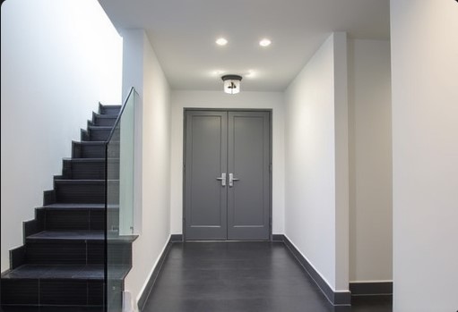 entrada comunitaria de bloque de pisos de vecinos en mataro pintada en blanco y la puerta del ascensor en gris